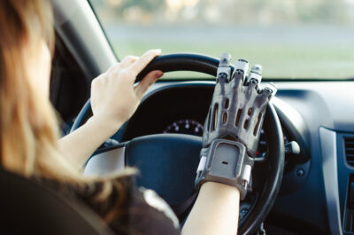 a man with a prosthetic arm printed on a 3D printer drives a car